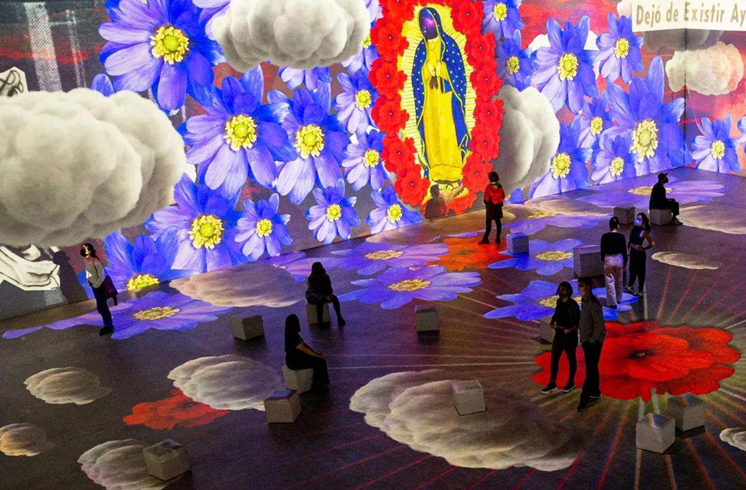 People walking in a vibrant Frida Kahlo art exhibition in Sydney.